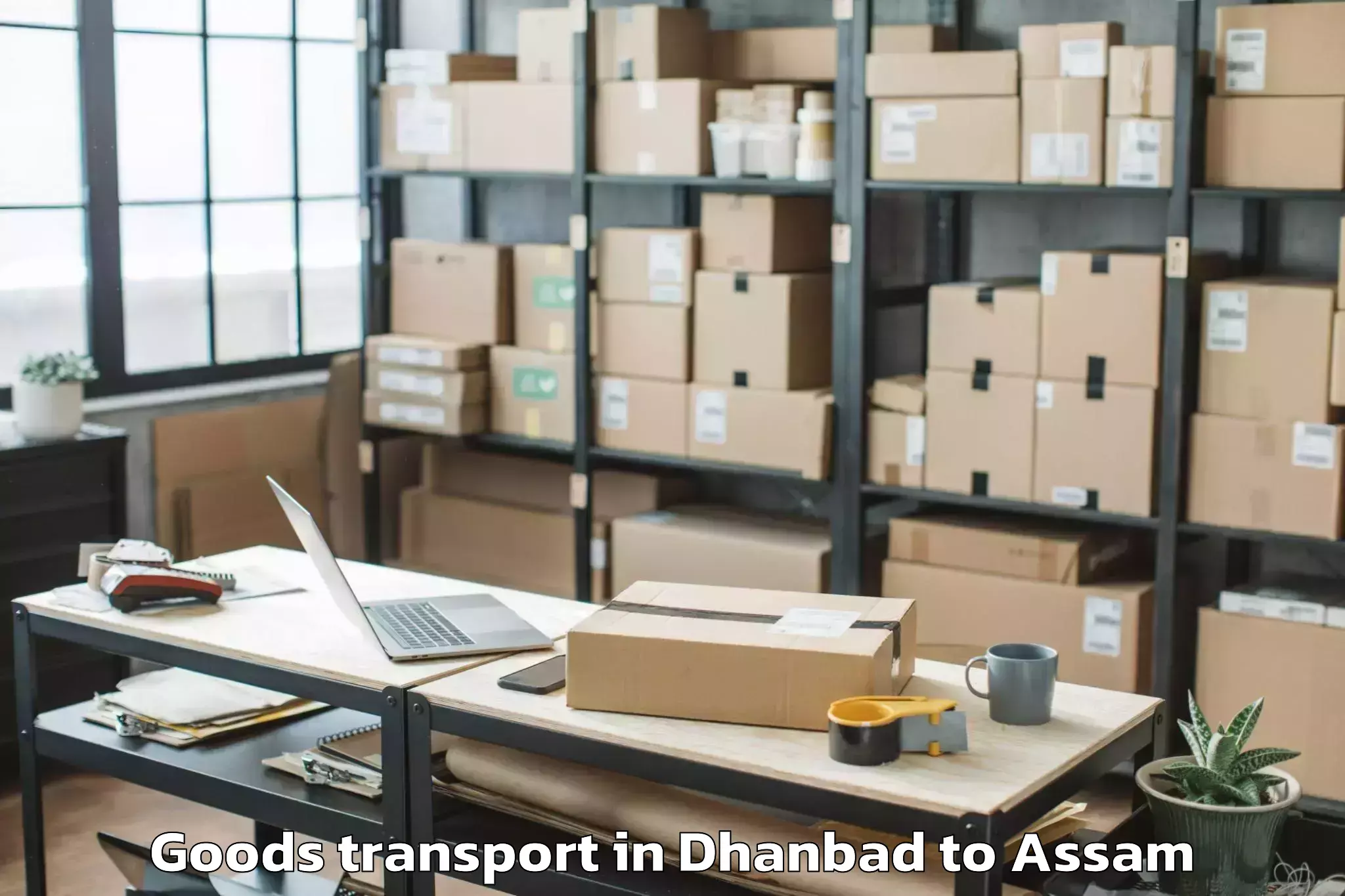 Quality Dhanbad to Muhimari Bilar Pathar Goods Transport